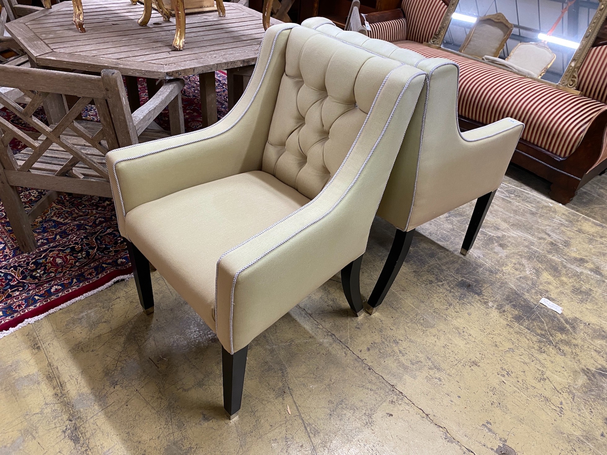 A pair of contemporary armchairs with deep buttoned backs on ebonised underframes, width 64cm, depth 68cm, height 99cm